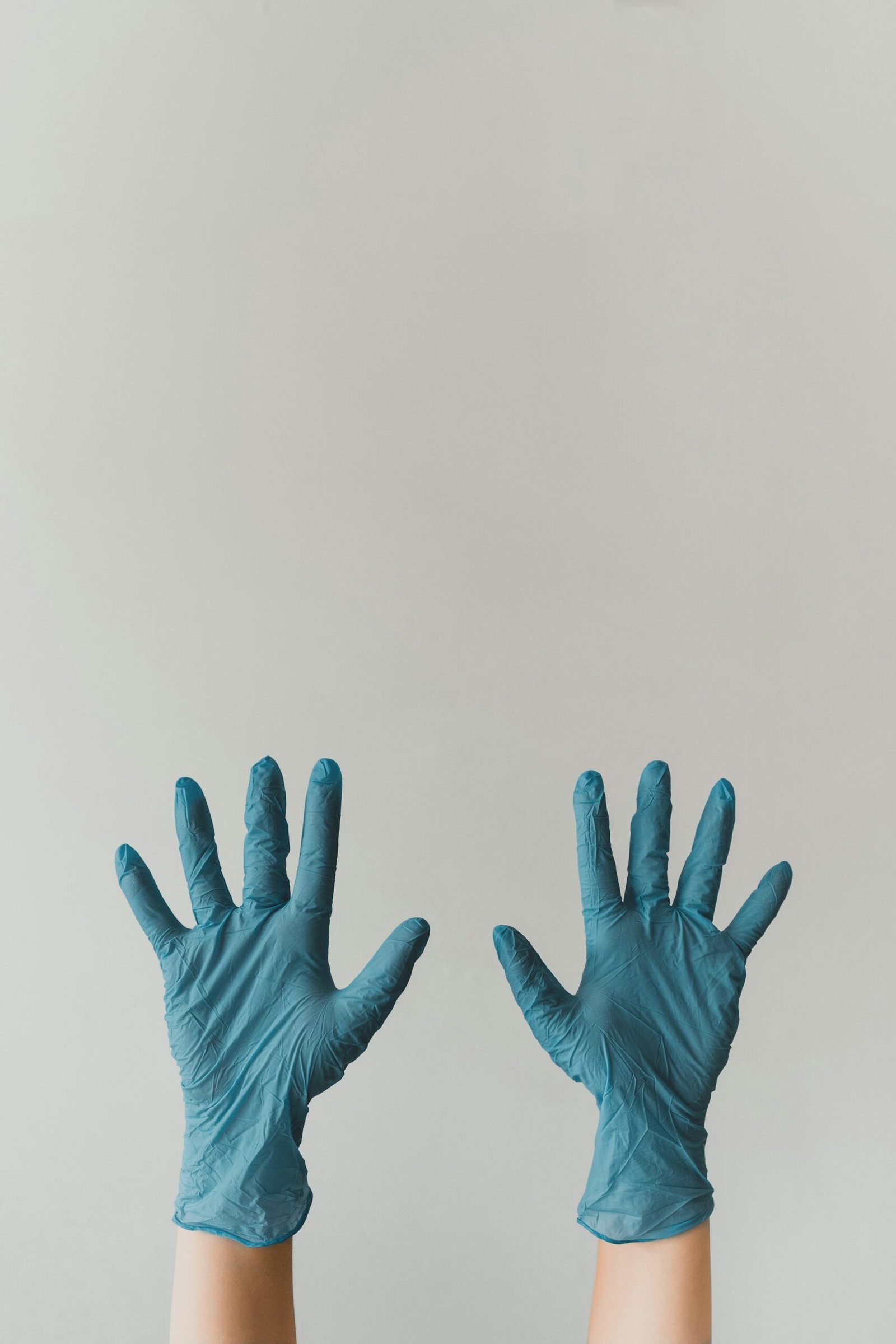 Blue rubber gloves on gray background